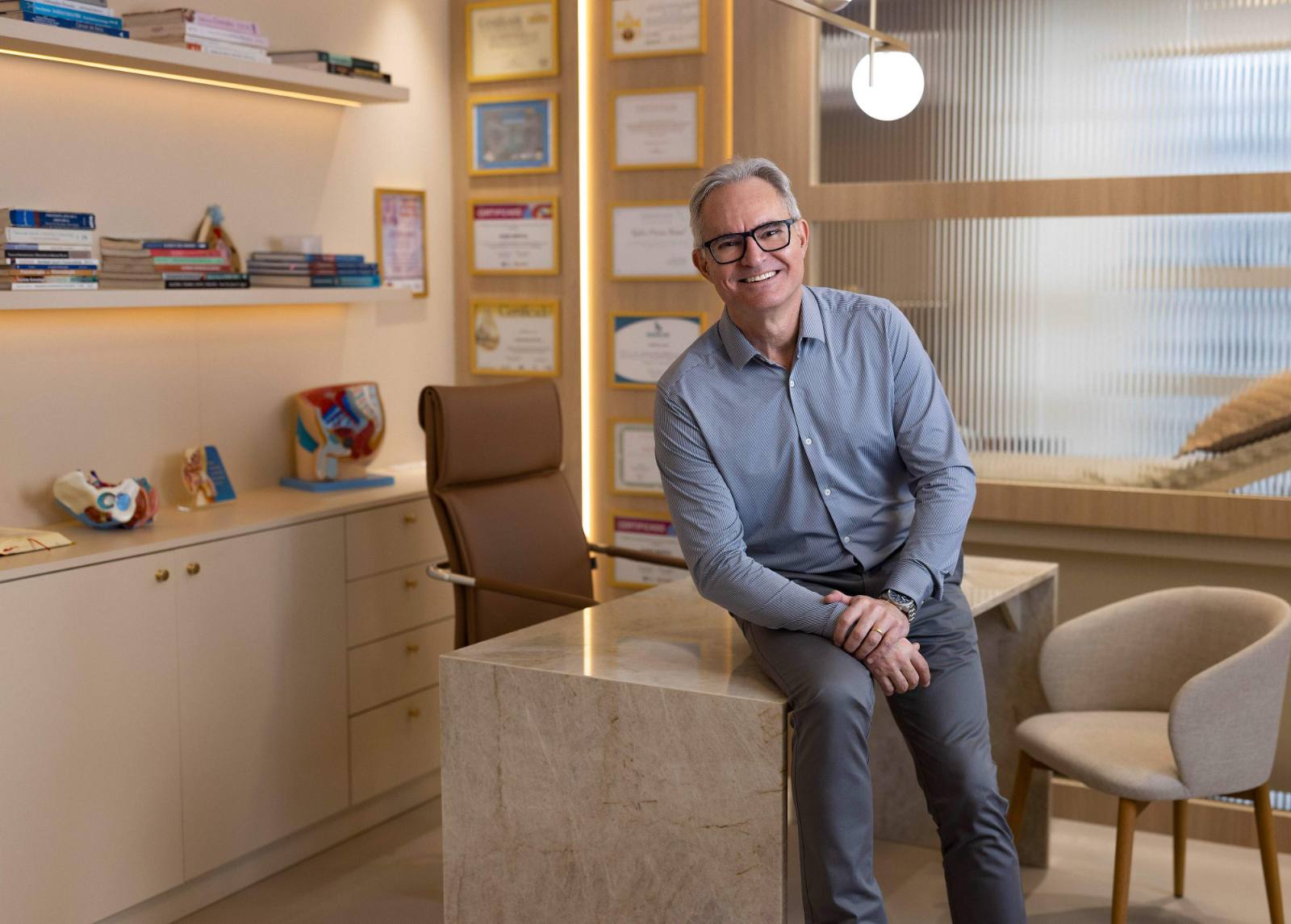 Dr. Evandro Vanti no consultório, em close, sorrindo de camisa azul